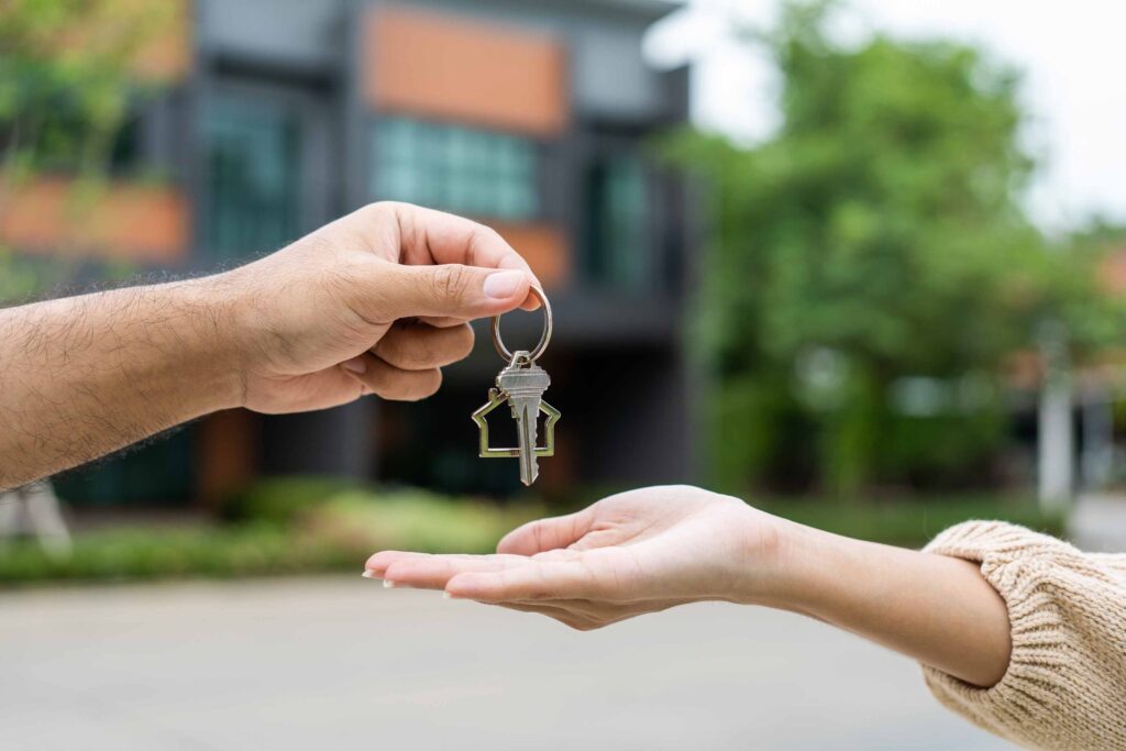 Woman buying or rent new home she holding key front of new house