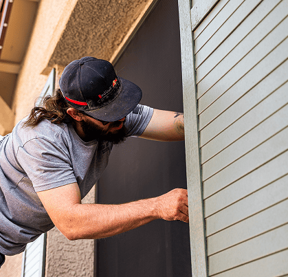 guardian security screens worker installing security screens window on a house