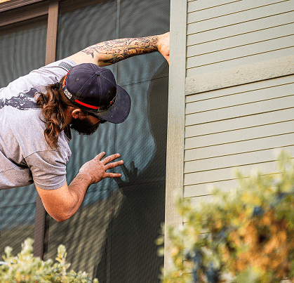 guardian security screens worker installing security screens window on a house