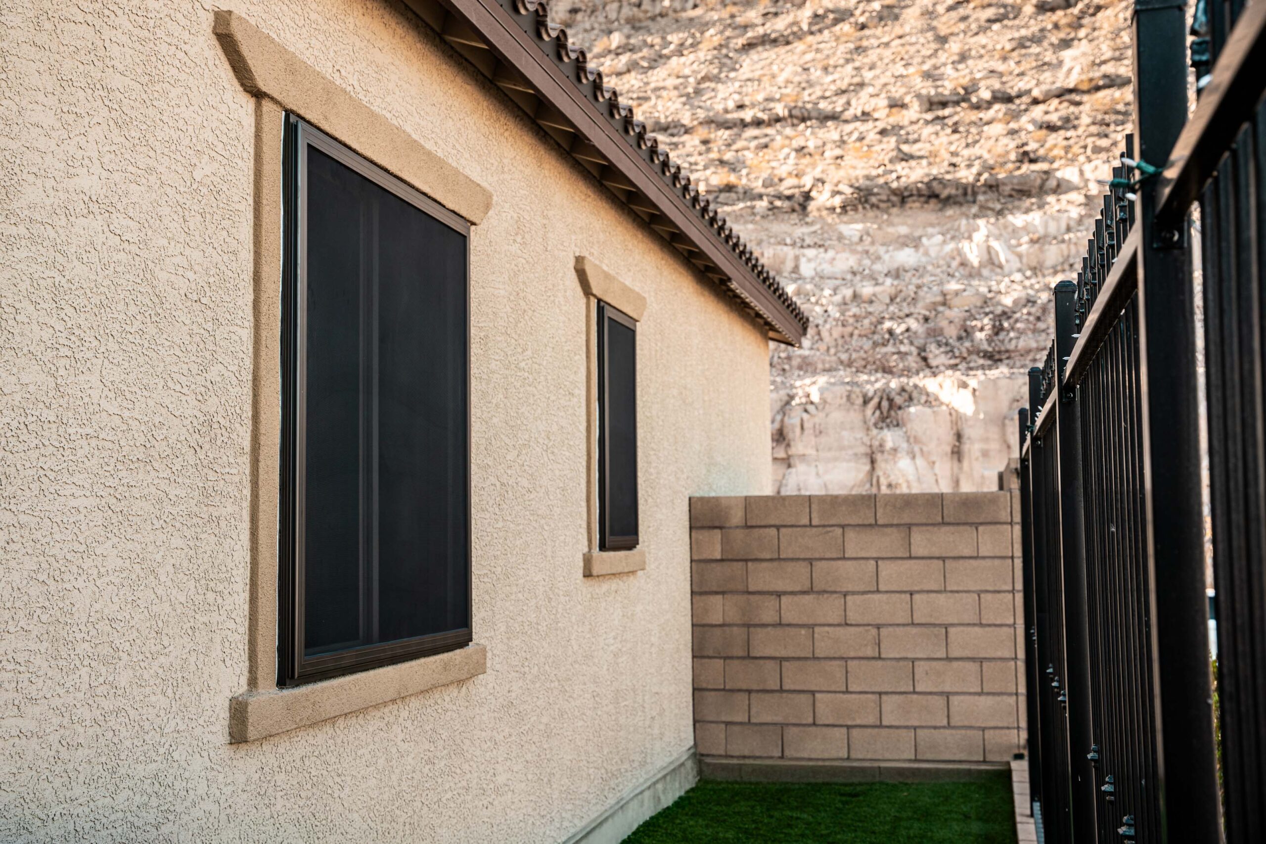 Side view of a home with Crimsafe security screens installed on windows for short-term rental protection and guest safety